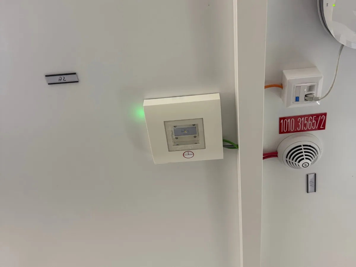 Rauchmelder und Sicherheitsleuchte an der Decke einer Modulbauanlage