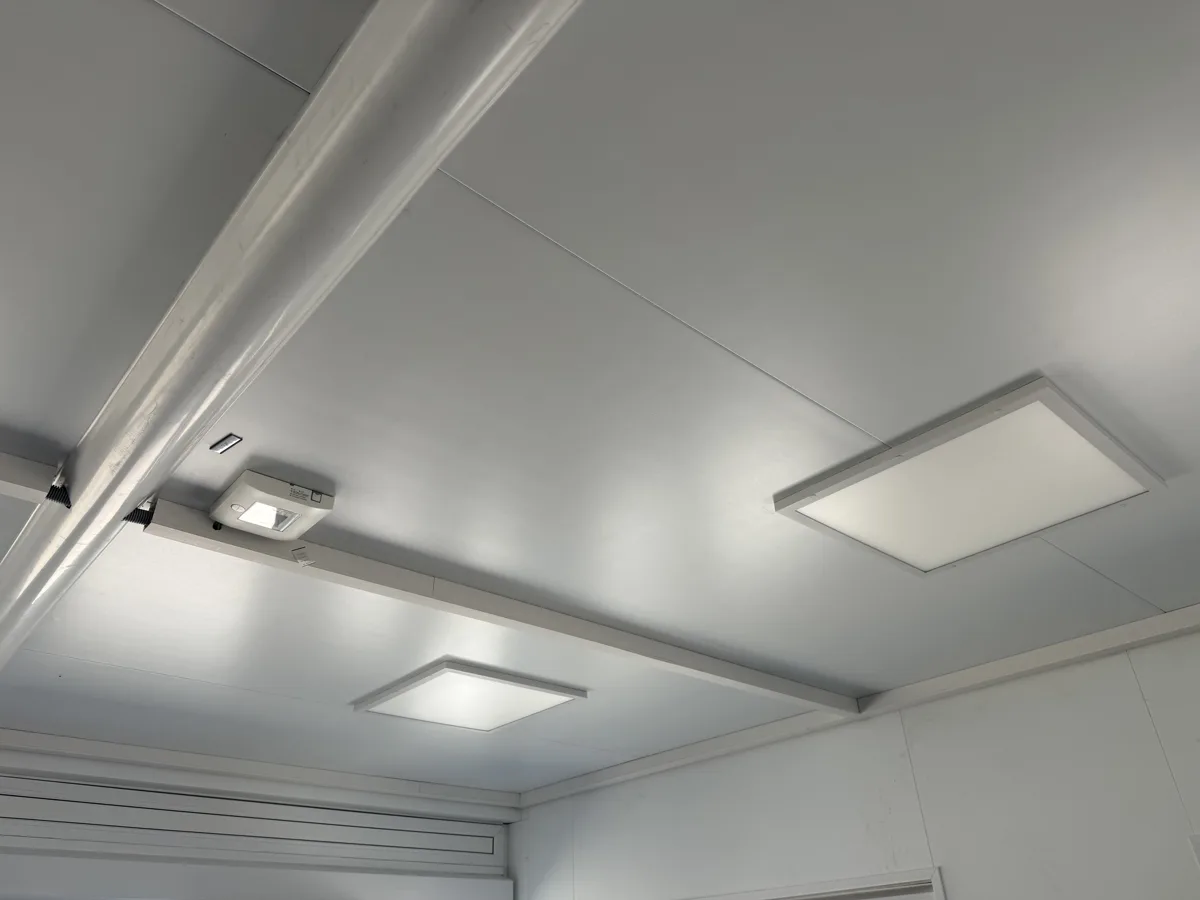 Heller Flur mit Deckenpaneln und Sicherheitsleuchte