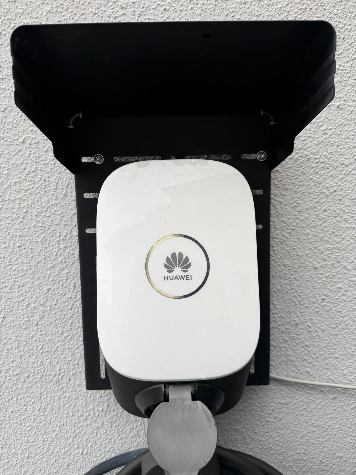 Huawei Wallbox mit Ladekabel an einer Hauswand